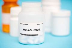 White Label Dulaglutide 1 gram powder container with blurred medicine bottles in background