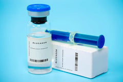 Glucagon 50mg vial with syringe and packaging on blue background for research use