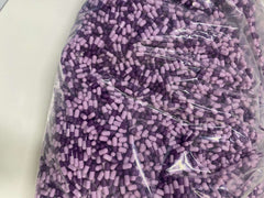 Bulk bag of purple and lavender Sermorelin 3mg capsules for pharmaceutical research and private labeling