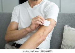 man applying natural hormone replacement therapy patch on arm